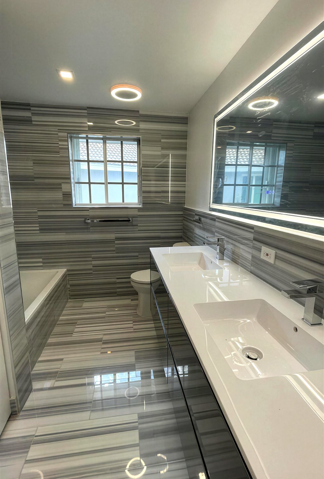Modern gray-striped bathroom with double vanity and LED mirror