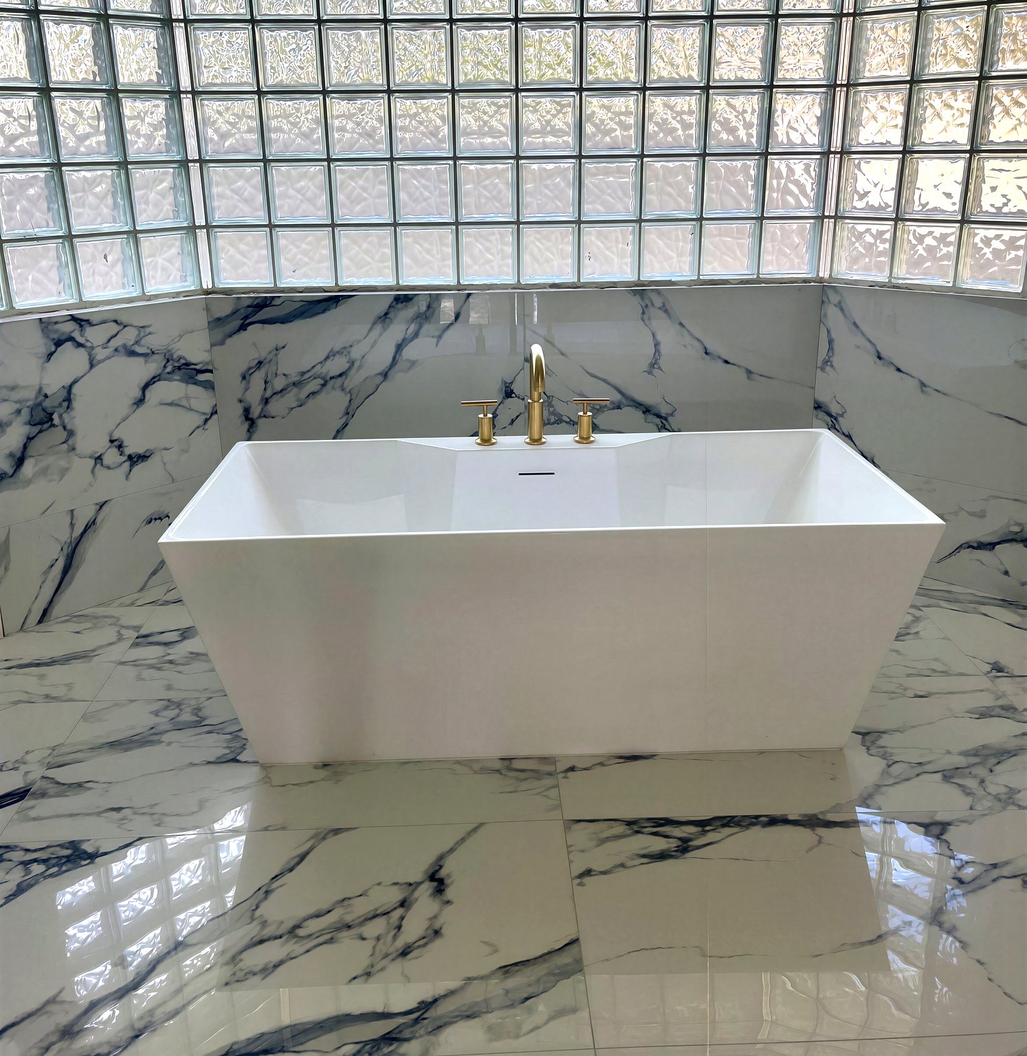 Freestanding soaking tub in marble bathroom